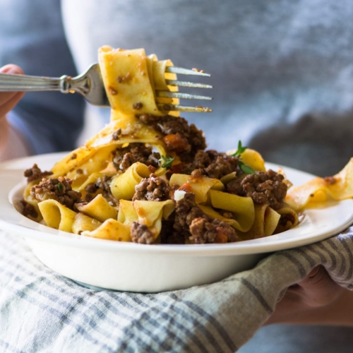 taking forkful of pasta Bolognese
