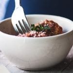 taking a bite of meatballs al forno