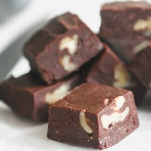 easy microwave fudge with walnuts, stacked with knife.