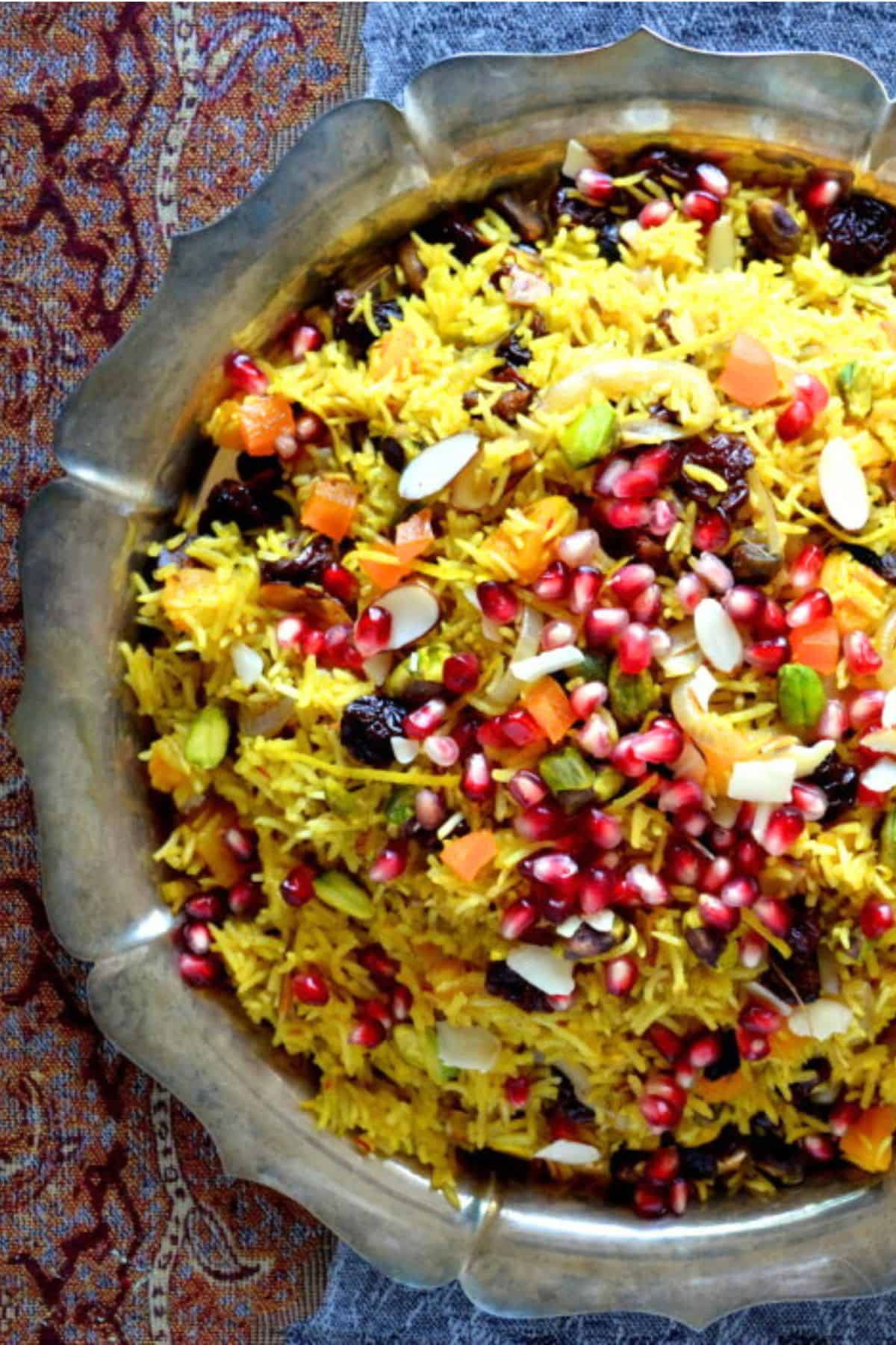 Persian Jeweled Rice is a gluten free, vegan rice pilaf topped with colorful gem-like fruits and nuts ~ this popular wedding dish is gorgeous! #easy #recipe #authentic #vegan #glutenfree #iranian #traditional #wedding #middleeastern #basmati #saffron #Christmas #passover #Easter Thanksgiving Persian jeweled rice on a silver tray.,