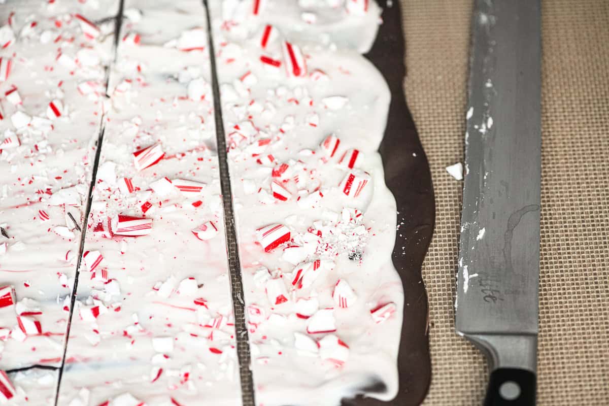 Slicing pepermint bark on a silpat mat.