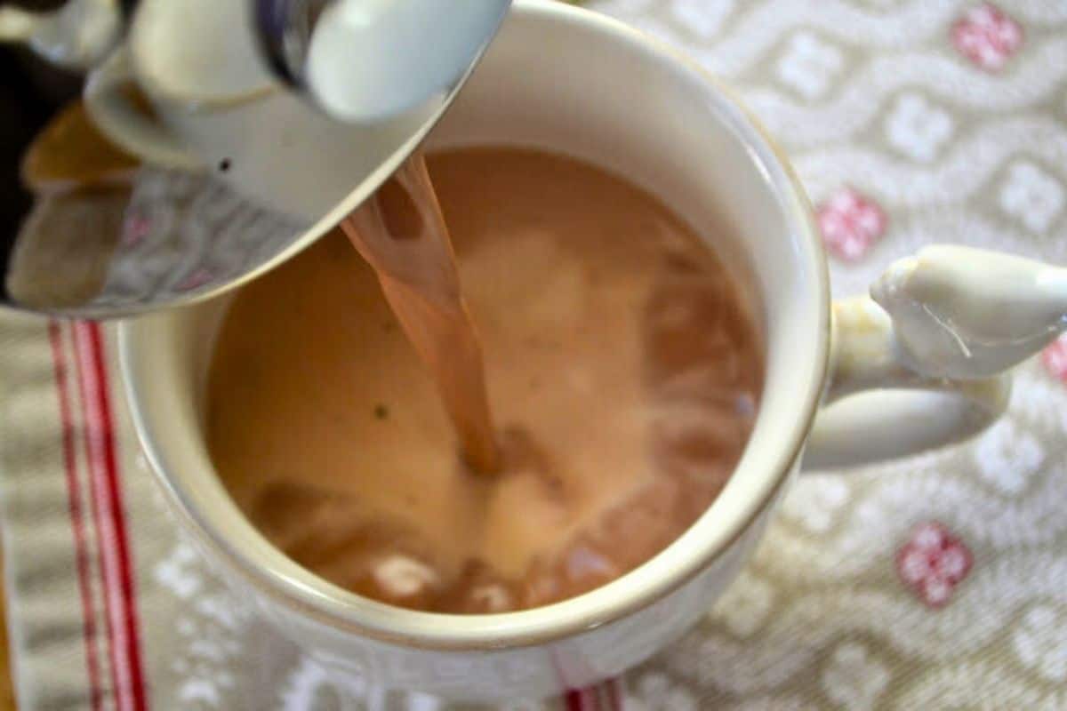 Pouring French Press Breakfast chocolate into a mug.