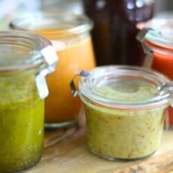 Colorful homemade fruit salad dressings in small Weck jars.