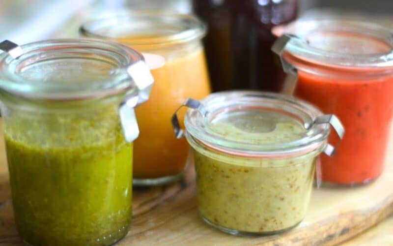 Colorful homemade fruit salad dressings in small Weck jars.