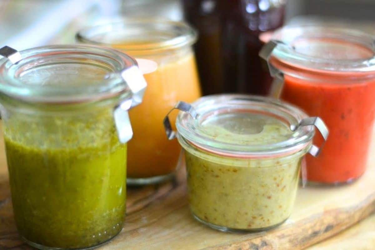 Colorful homemade fruit salad dressings in small Weck jars.