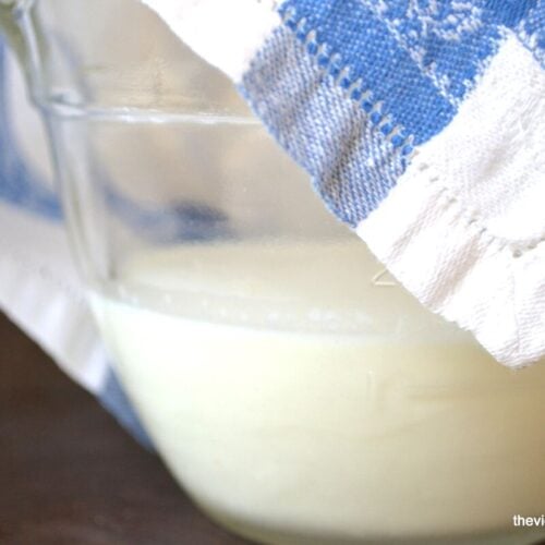Homemade Crème fraîche in a bowl covered by a dishcloth.