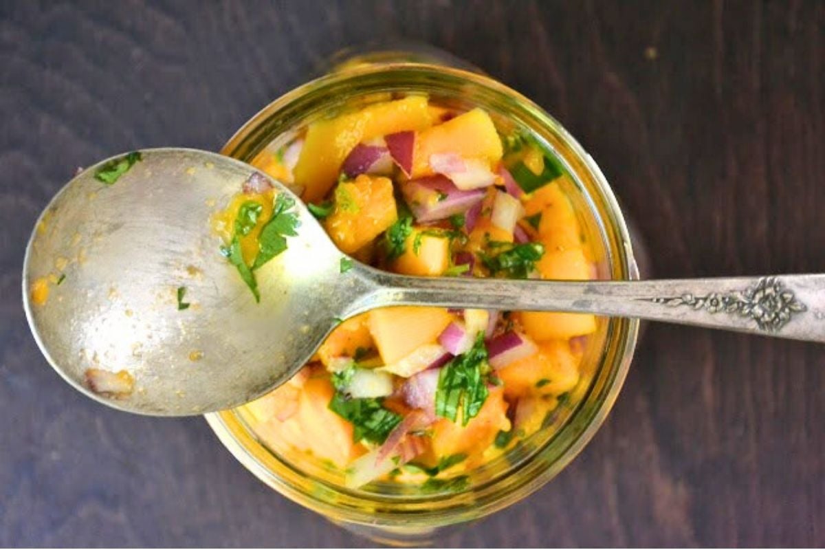 a jar of papaya salsa, with spoon.