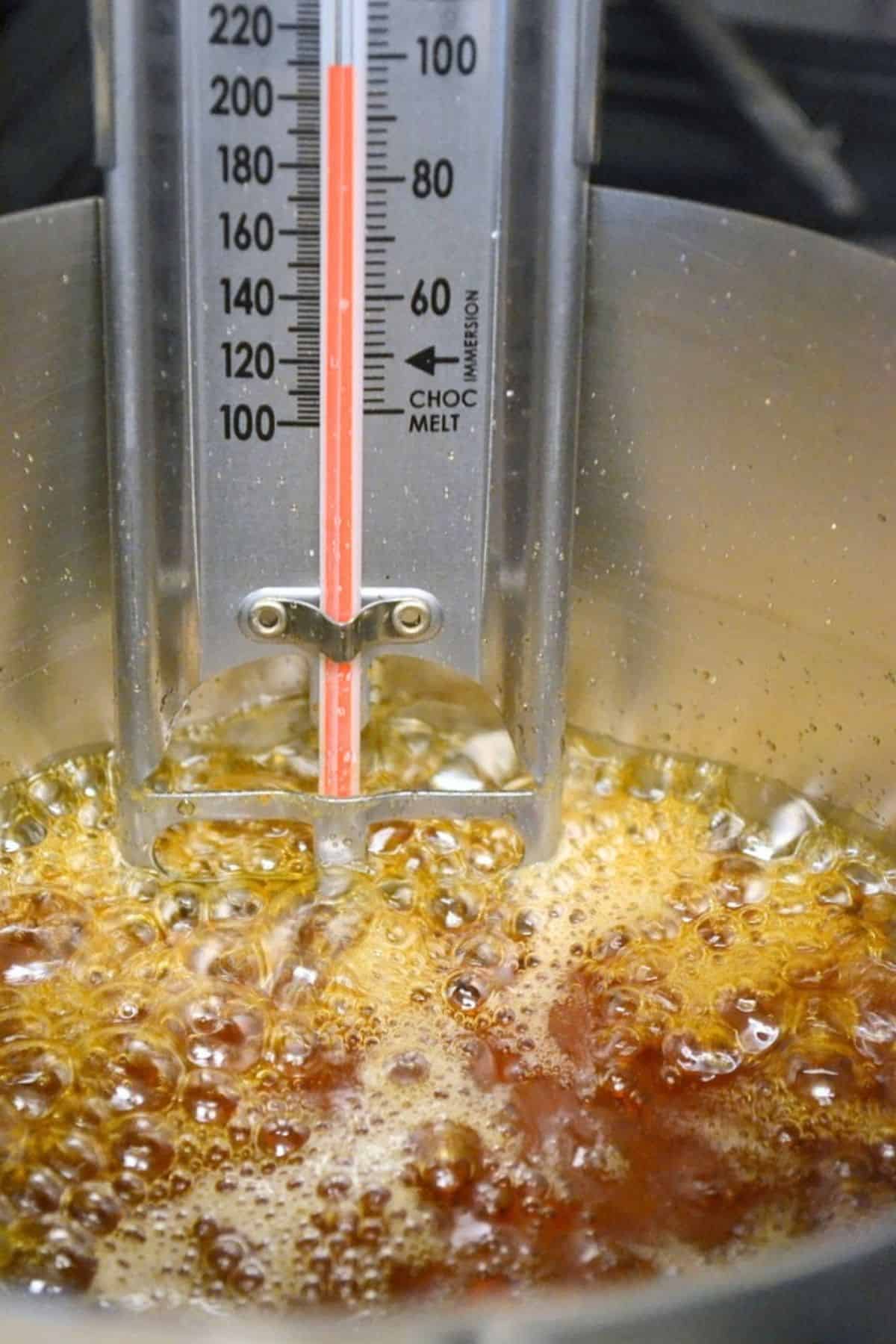 a thermometer in a pan of boiling maple syrup.