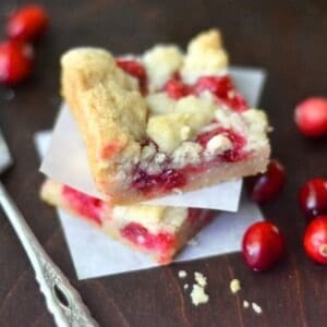 Fresh cranberry bars, stacked, with fork.