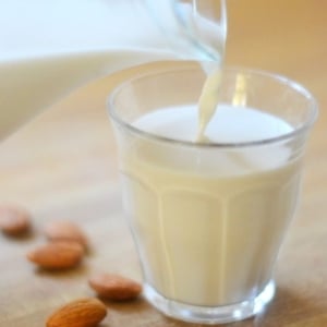 Photo of almond milk being poured into a glass.