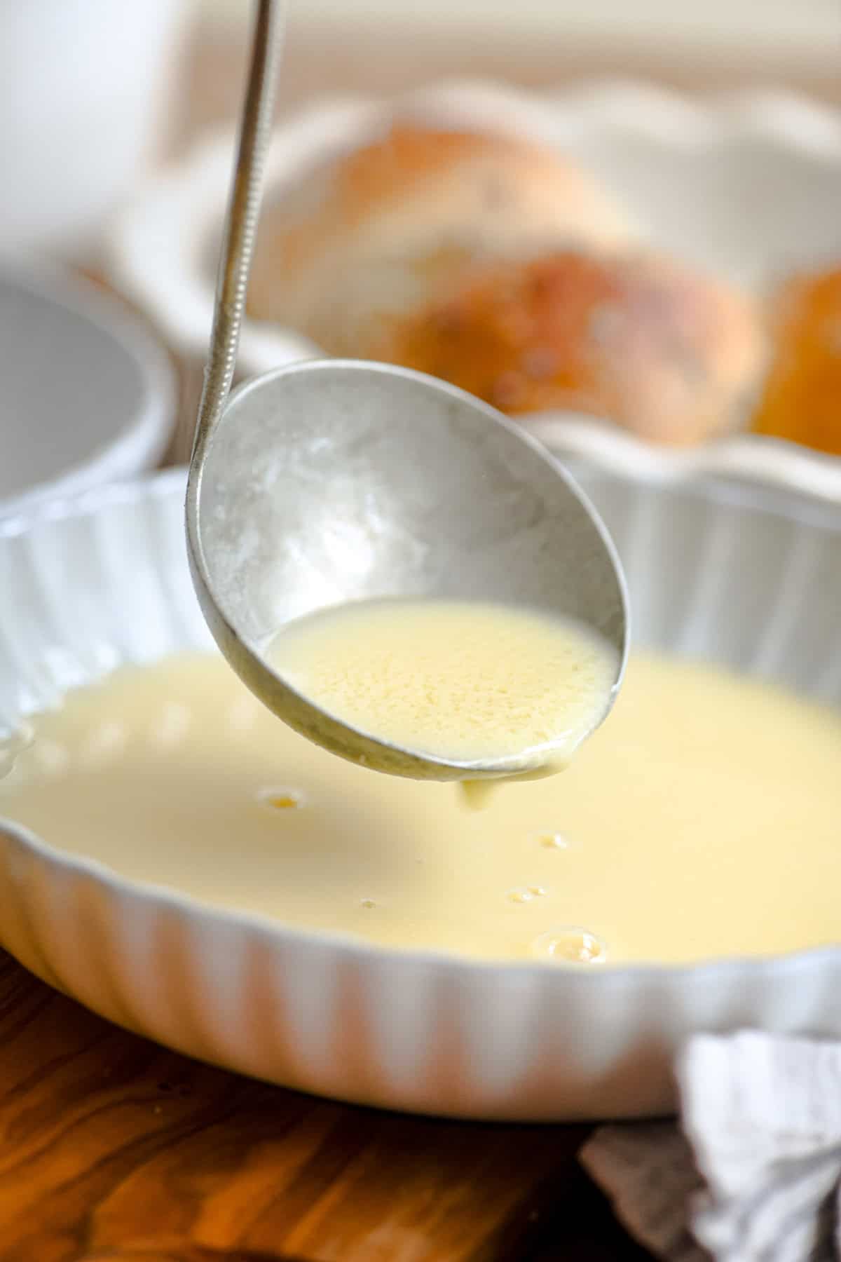 Avgolemono Soup is a fabulously lemony chicken and rice soup made super creamy without any cream! It's classic Greek comfort food. #soup #greek #lemon #recipe #homemade #healthy #chickensoup #rice #easy #best ladling avgolemono soup into a bowl.