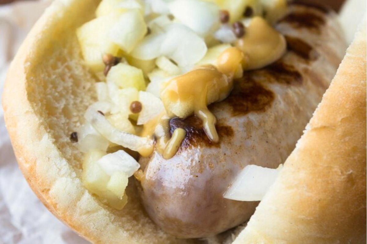 cider brat grilled and on a bun with mustard and apple onion relish.