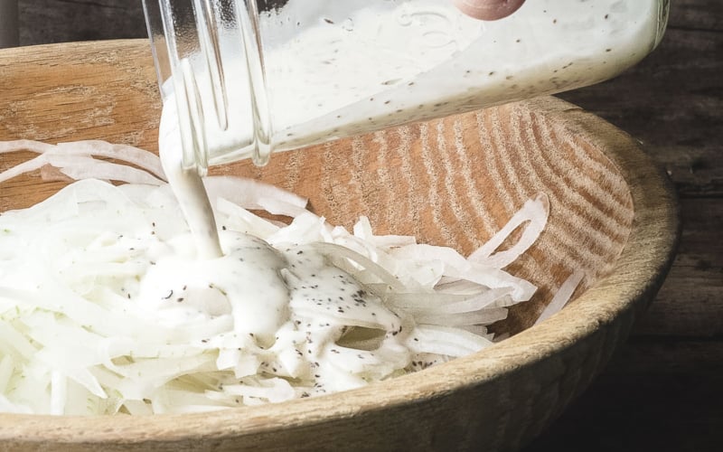 Pouring dressing over vidalia onions.