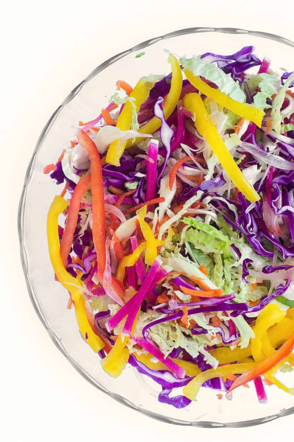 Rainbow slaw in a bowl, before adding dressing.