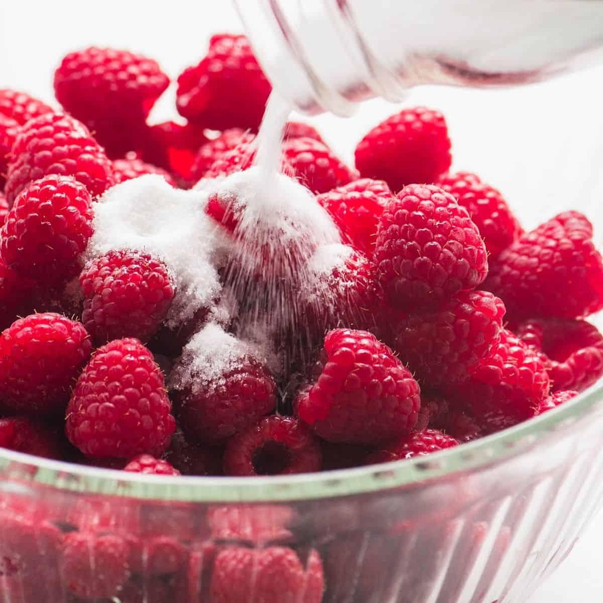 raspberries in a bowl, with sugar.