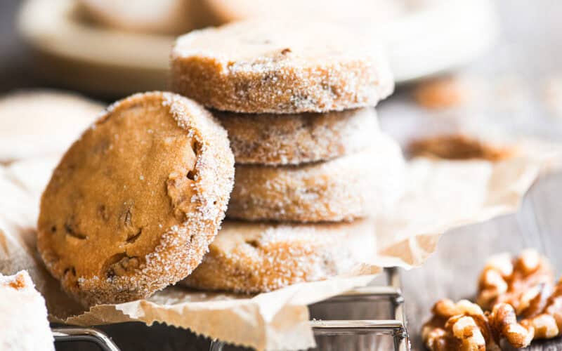 a stack of maple walnut shortbread cookies on a rack.