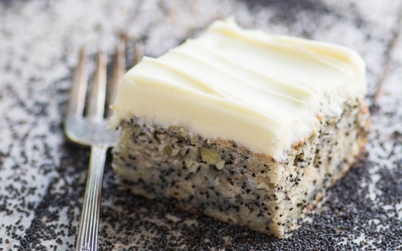 A piece of banana cake on a plate, with frosting