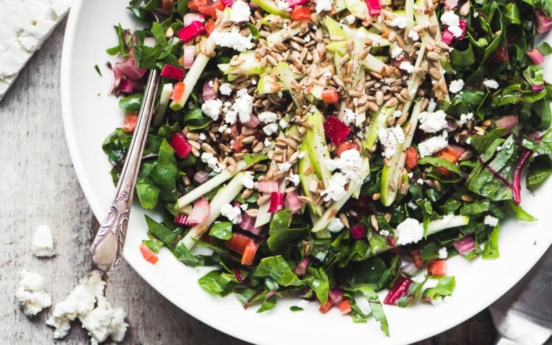 Rainbow Chard Salad in a white bowl with spoon