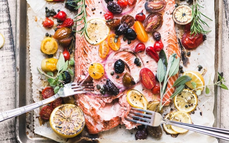 Mediterranean roasted sheet pan salmon with tomatoes, olives, onion, and lemon
