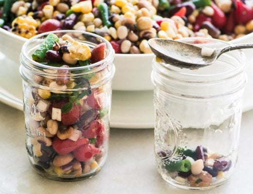 Spooning Charred Corn and Bean Salad into mason jars