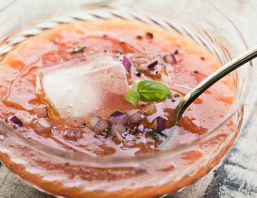 apricot gazpacho in a glass bowl with an ice cube