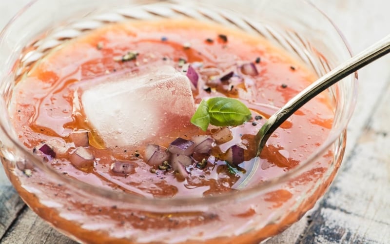 apricot gazpacho in a glass bowl with an ice cube