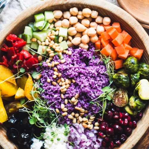 Colorful purple cauliflower rice salad in a wooden bowl