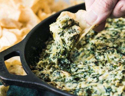 Scooping up Smokey Spinach and Artichoke Dip with a chip