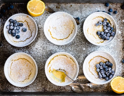 Warm lemon puddings on a baking sheet with blueberries