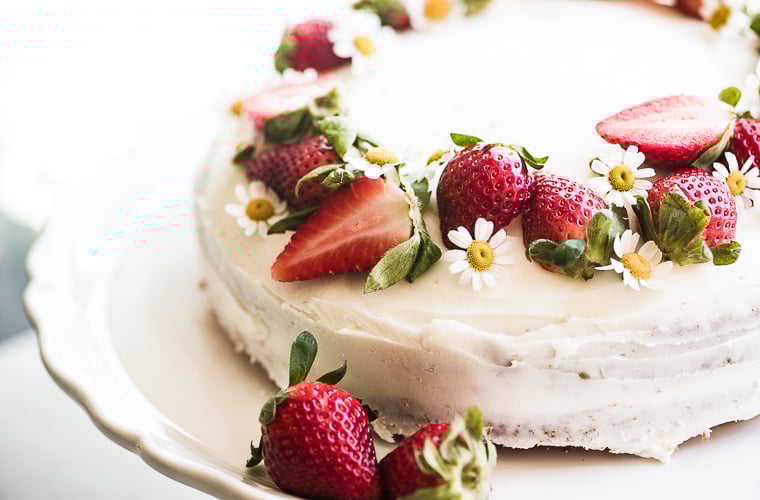Fresh strawberry cake topped with strawberries and flowers