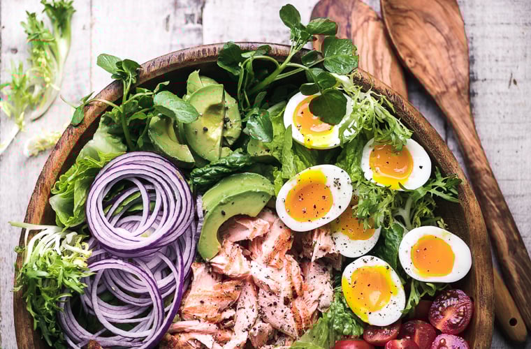 Salmon Cobb Salad in a wooden salad bowl with salad spoons