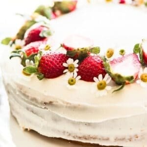 fresh strawberry cake topped with berries.