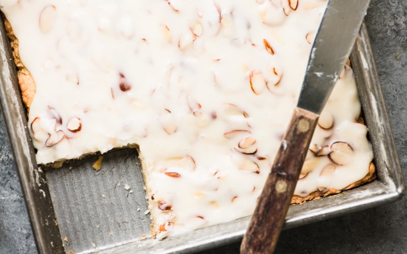 A pan of almond blondies with a slice removed