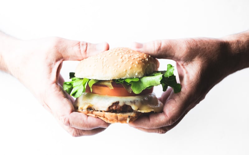 holding a plant based burger with all the fixings