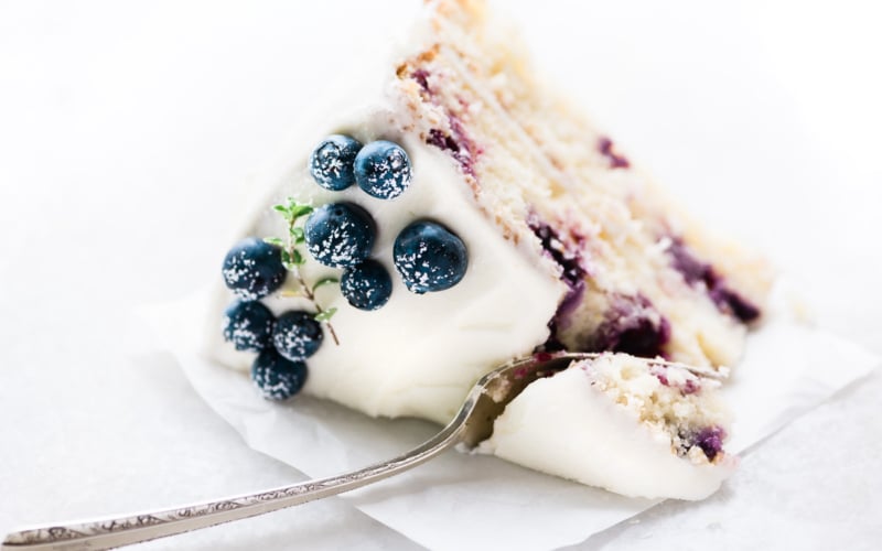 a slice of blueberry lemon layer cake with fork