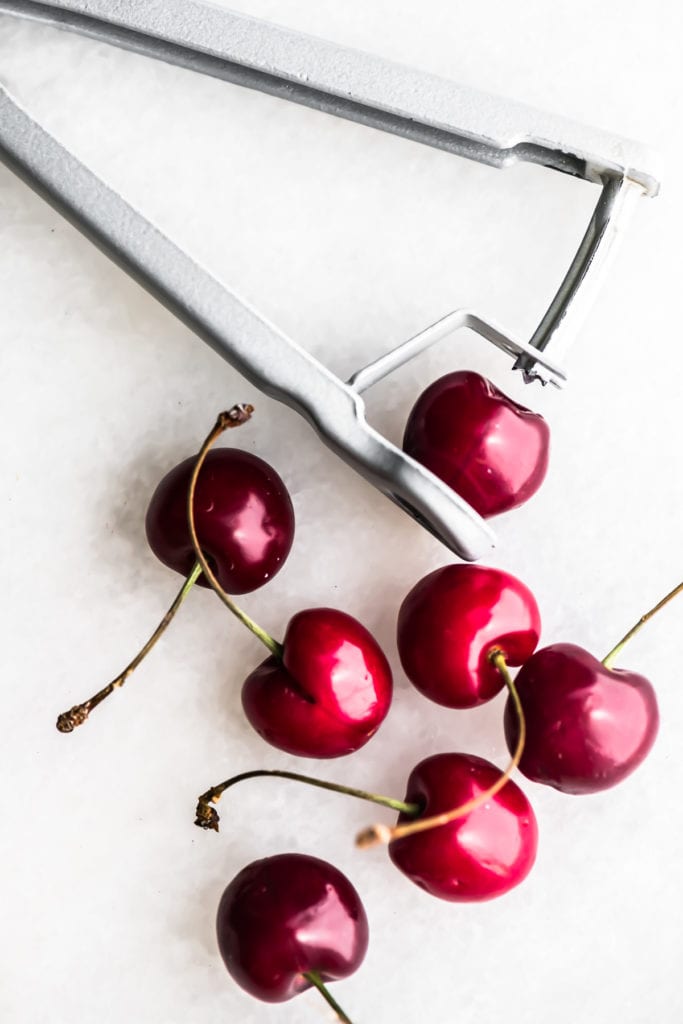 pitting fresh cherries with a cherry pitter