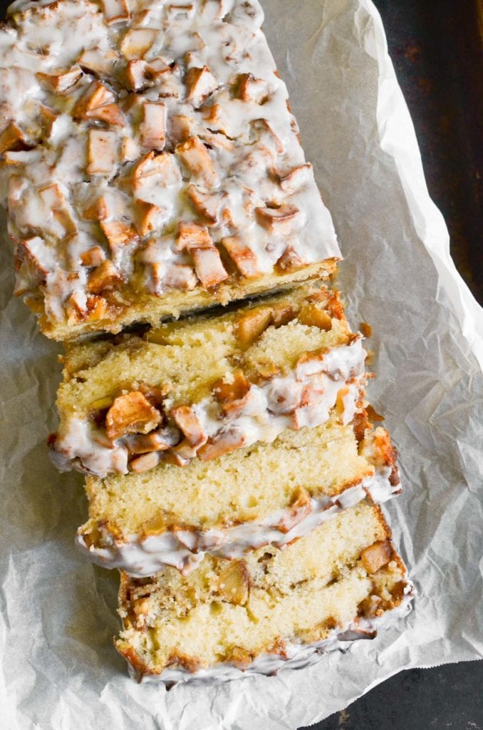 Apple fritter bread, sliced, on a piece of parchment paper.
