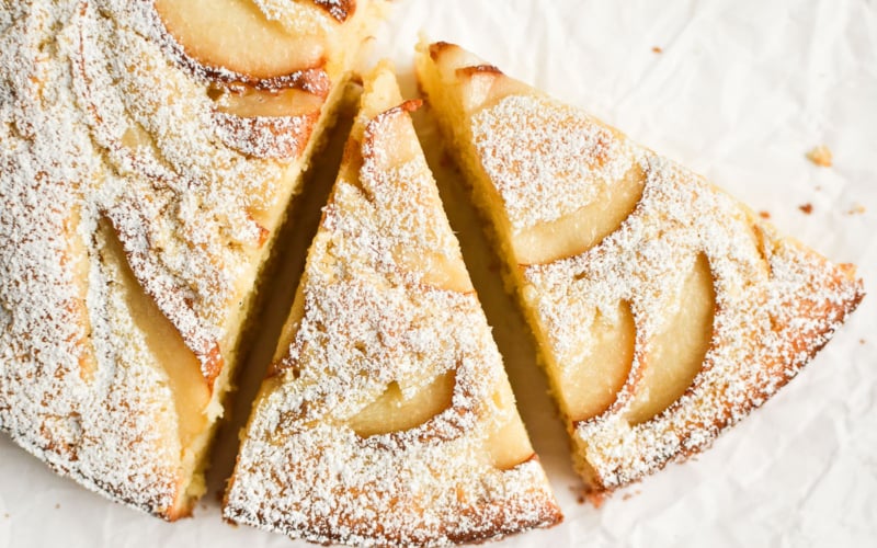 Ginger pear cake, sliced, on a piece of parchment paper.