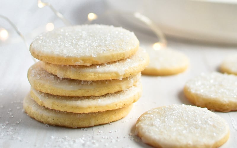 A stack of new fallen snow cookies on a white surface.