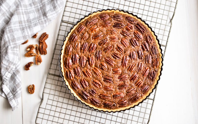 Pecan frangipane pie on a baking rack.