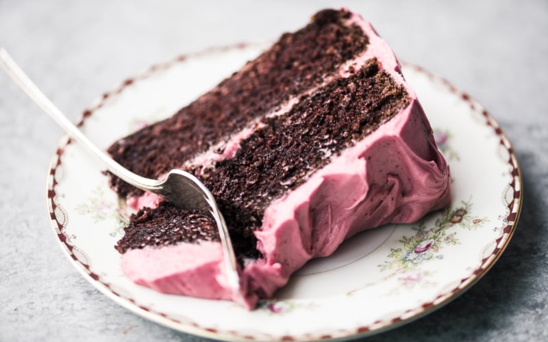 a slice of chocolate cake with cranberry buttercream