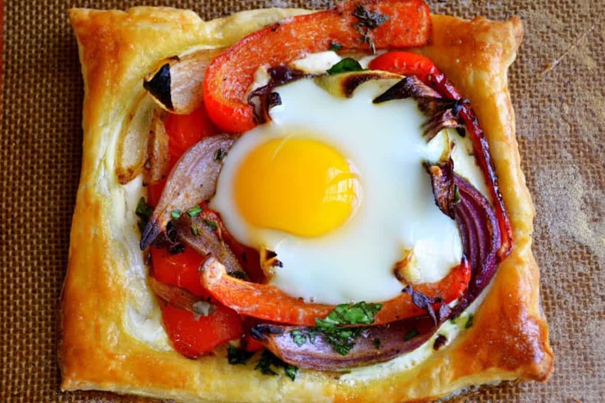Red Pepper and Baked Egg Galettes from Jerusalem (the book) ~ these eggs baked in puff pastry are the ultimate breakfast in bed recipe! #eggs #breakfast #brunch #puffpastry #bakedeggs #breakfastinbed #mothersday #valentinesday #Christmasbreakfast #holidaybreakfast #ottolenghi #jerusalem Puff pastry egg galette with red peppers.
