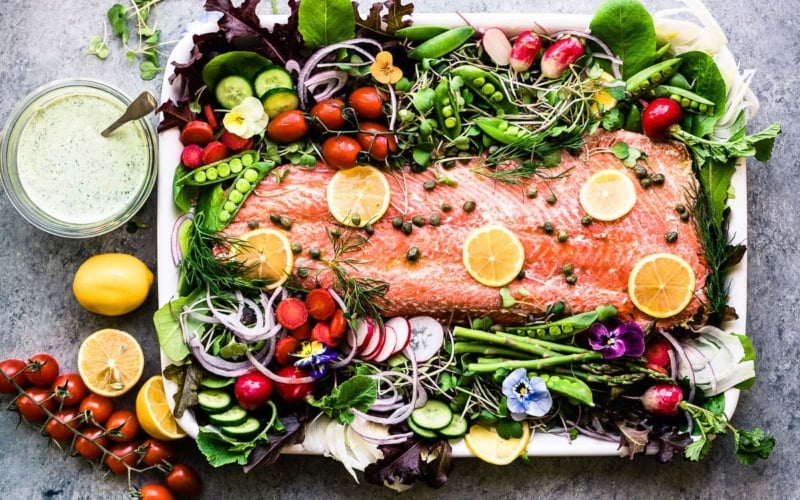 spring salmon salad on a white platter with fresh veggies