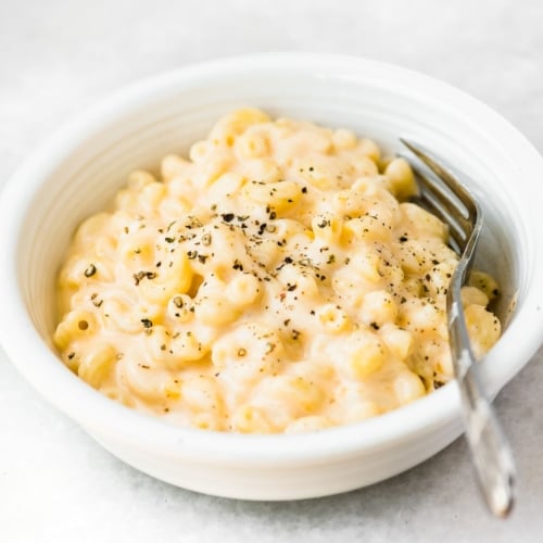 A bowl of creamy mac and cheese with spoon.