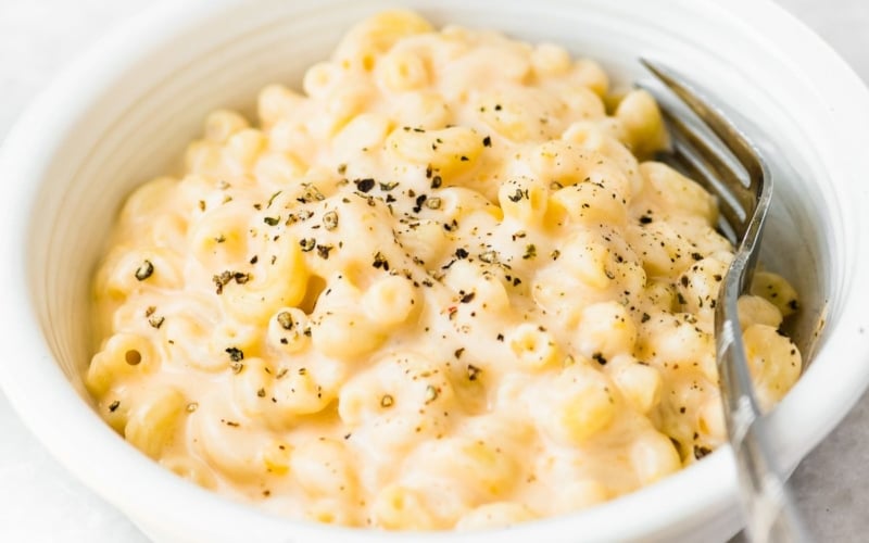A bowl of creamy mac and cheese with spoon.