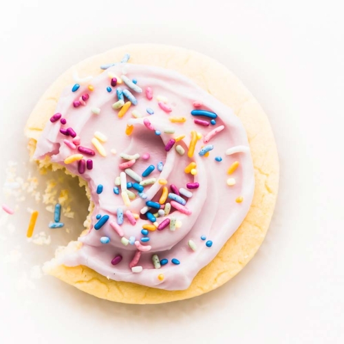 A pink frosted sugar cookie with sprinkles