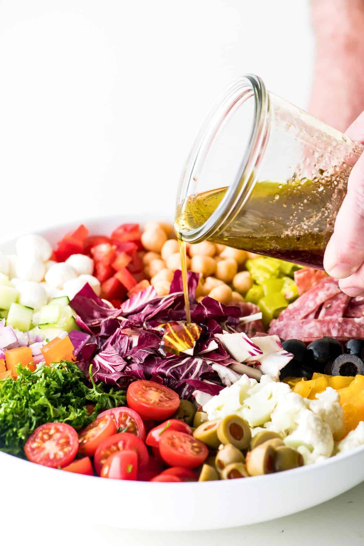 drizzling dressing onto a chopped Italian salad.