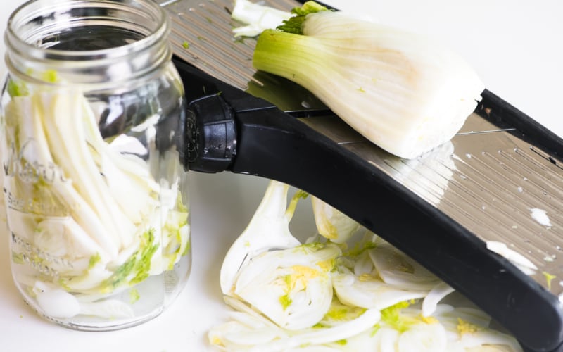 slicing fennel on a mandoline slicer
