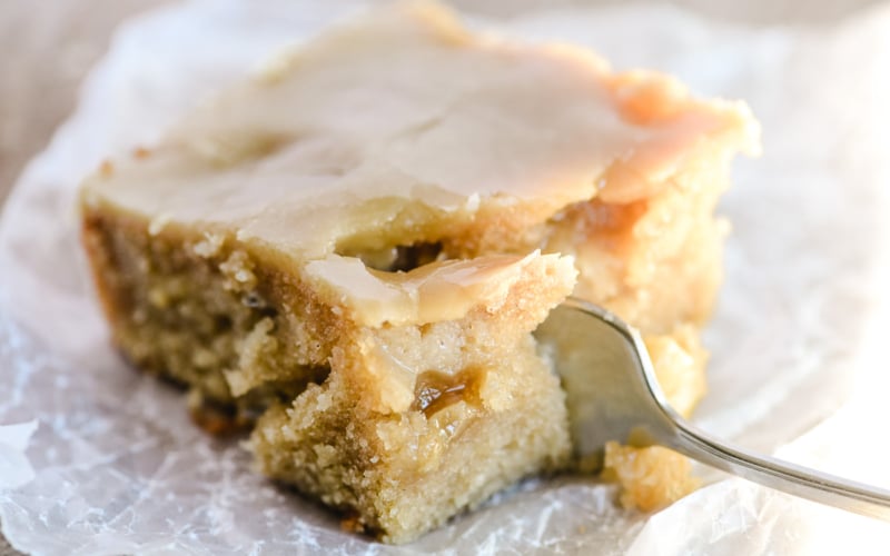 taking a bite of a piece of caramel glazed apple cake