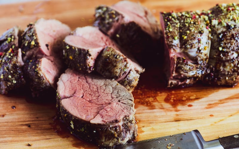 slicing beef tenderloin on a cutting board
